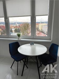 una mesa y 2 sillas en una habitación con ventanas en Apartment Kuzmany, en Košice