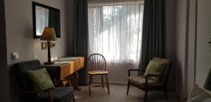 Cette chambre dispose d'un bureau, de chaises et d'une fenêtre. dans l'établissement Summer Place Guest House, à Port Edward