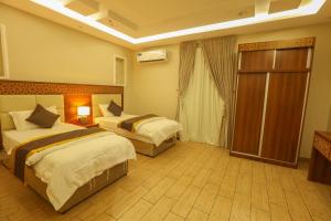 a hotel room with two beds and a balcony at Velvet Resort in Taif