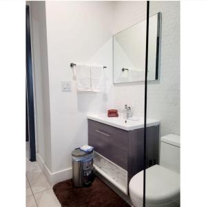 a white bathroom with a sink and a toilet at Loft in Paradise in Nassau