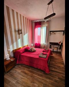 een slaapkamer met een rood bed en een piano bij PietraViva Casa vacanze FAICCHIO, NON VISANTI in Visanti