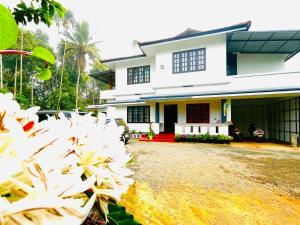 a house with white flowers in front of it at Sahyadri Homestay wayanad in Kalpetta