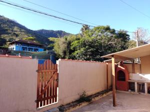 einen Zaun mit einem Tor vor einem Haus in der Unterkunft Casa Rota dos Vales in Miguel Pereira