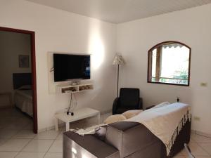 ein Wohnzimmer mit einem Sofa und einem TV in der Unterkunft Casa Rota dos Vales in Miguel Pereira