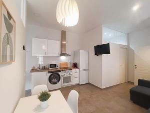 a kitchen with a refrigerator and a table with chairs at Apartamentos Rincón de Vinatea in Castellón de la Plana