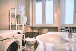 uma casa de banho com uma máquina de lavar roupa e um lavatório em La Voliera em Verona