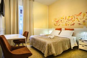 um quarto de hotel com uma cama, uma secretária e uma cadeira em La Voliera em Verona