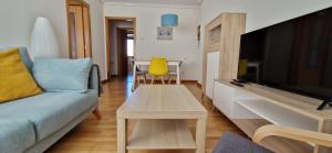 a living room with a couch and a tv and a table at Apartamento I&F Colombres by Casas de Los Picos in Colombres