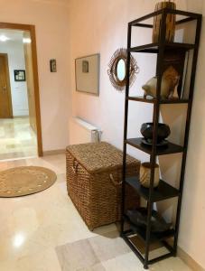 a black shelving unit in a room with a basket at Suite privée dans un appartement à partager in El Aouina