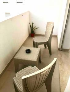 El AouinaにあるSuite privée dans un appartement à partagerの椅子2脚、テーブル1台、テーブル1脚、椅子1脚