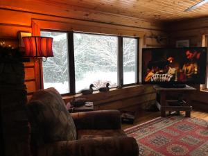 a living room with a couch and a large window at Restful Retreat in Grantsburg