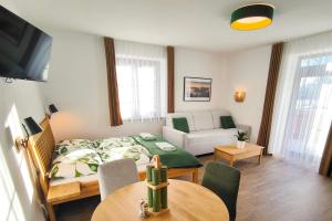 a living room with a bed and a couch at Apartmány Lipno-Hory in Horní Planá