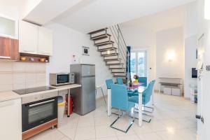 a kitchen with a table and chairs and a spiral staircase at Apartment Ruzmarinka with Spacy Terrace in Baška