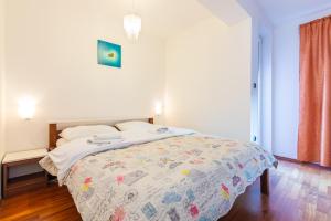 a bedroom with a bed with a comforter on it at Apartment Ruzmarinka with Spacy Terrace in Baška