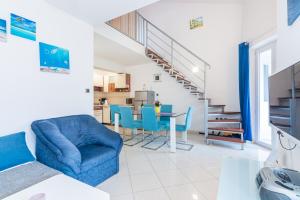 a living room with a blue couch and a table at Apartment Ruzmarinka with Spacy Terrace in Baška