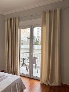 1 dormitorio con 1 cama y puerta corredera de cristal en Acropolis Luxury Apartments Parthenon view en Athens