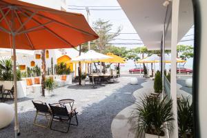 un patio con tavoli, sedie e ombrelloni di PAL coffee & homestay a Vung Tau