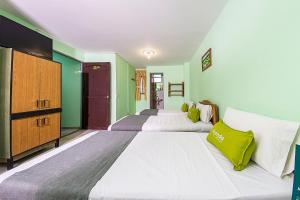 duas camas num quarto com paredes verdes em Hotel El Bosque em Armênia
