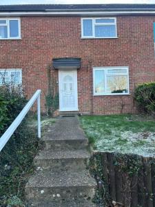 a brick house with a white door and stairs at Quiet location 2 bed house 