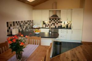 a kitchen with a table with a vase of flowers on it at Plum Tree Lodge in Errol