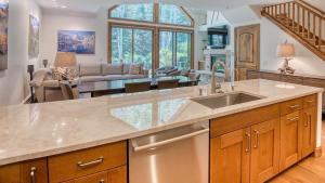 a kitchen with a sink and a living room at Icegrass Chalet in Edwards