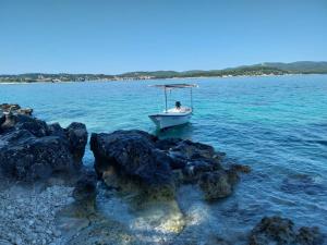a boat in the water next to some rocks at Apartments Lumbarda in Lumbarda