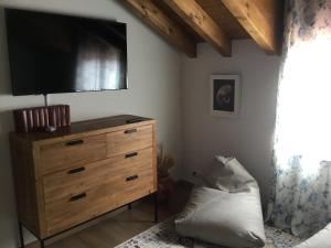 1 dormitorio con vestidor y TV de pantalla plana. en Los acebos el atico, en Gallejones