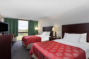 ein Hotelzimmer mit 2 Betten und einem Flachbild-TV in der Unterkunft 88 Palms Hotel & Event Center in West Palm Beach