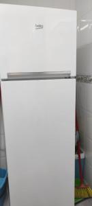 um frigorífico branco com uma tampa prateada numa cozinha em Appartement avec vue sur baie de Malaga em Torre de Benagalbón