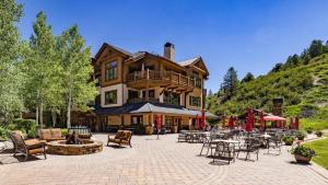 a large building with a patio with tables and chairs at Clover Chalet in Edwards