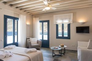 a bedroom with two beds and a ceiling fan at Sifnos House - Rooms and SPA in Kamares