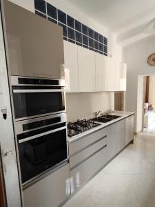 une cuisine avec des appareils électroménagers en acier inoxydable et des armoires blanches dans l'établissement La Luna sul Porto, à Santa Margherita Ligure