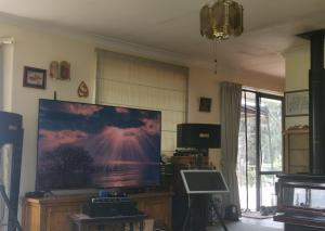 a living room with a large flat screen tv at Real Relax Ninety-Nine in Maungatapere