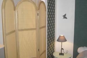 a room with a door with a lamp on a table at Lou mas li Pitchoun "Le Poirier" in Gordes