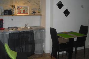 a kitchen with a sink and a table with chairs at Le Poirier in Gordes