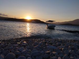 a small boat on the water at sunset at Apartments Lumbarda in Lumbarda