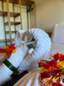 Oka Pousada Atins في أتينز: منشفة فوق سرير مع ورود