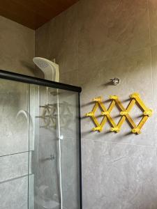 a bathroom with a shower and two crosses on the wall at Oka Pousada Atins in Atins