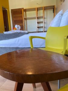een tafel en een stoel in een kamer met een bed bij Oka Pousada Atins in Atins
