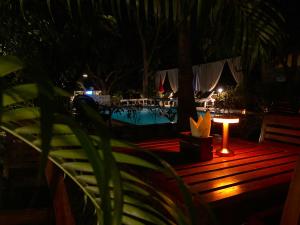 a night view of a pool and a table with a candle at Aaria Hills in Arambol