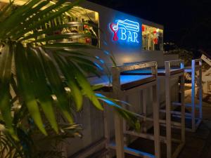 a bar with a blue neon sign and a plant at Aaria Hills in Arambol
