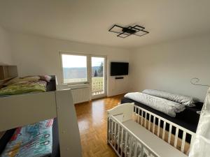 a room with two beds and a crib in it at Meli's Zirbenbett Ferienappartment in Bernstein
