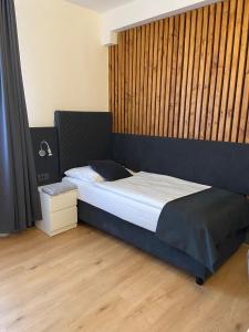 sypialnia z łóżkiem i drewnianą podłogą w obiekcie Penzion Stella w Prościejowie