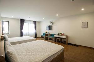 Habitación de hotel con 2 camas y sofá en ANH TU Hotel, en Lạng Sơn