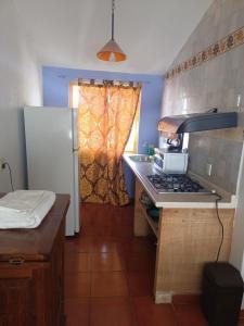 a small kitchen with a stove and a sink at Hostal Mago in Tlaxcala de Xicohténcatl