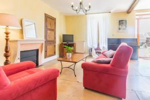 a living room with two red chairs and a fireplace at Maison de 2 chambres avec jardin amenage et wifi a Eringes in Éringes