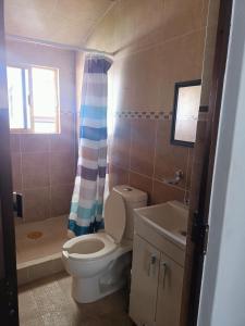 a bathroom with a toilet and a sink and a shower at Hostal Mago in Tlaxcala de Xicohténcatl