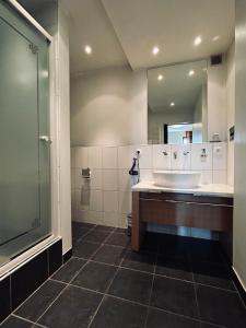 a bathroom with a tub and a sink and a mirror at Hotel BRASSERIE in Erlangen