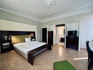 a bedroom with a bed and a television in it at Hotel BRASSERIE in Erlangen