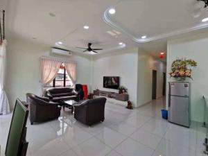a living room with couches and a tv at CK Homestay K.Sepetang in Taiping